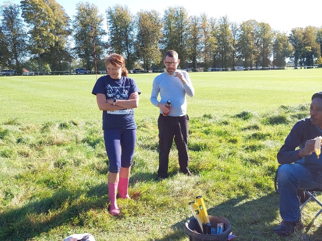 A group of people standing in a field

Description automatically generated