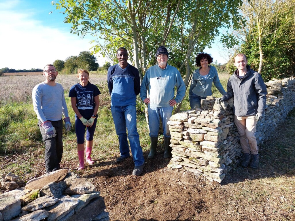 A group of people standing next to a stone structure

Description automatically generated