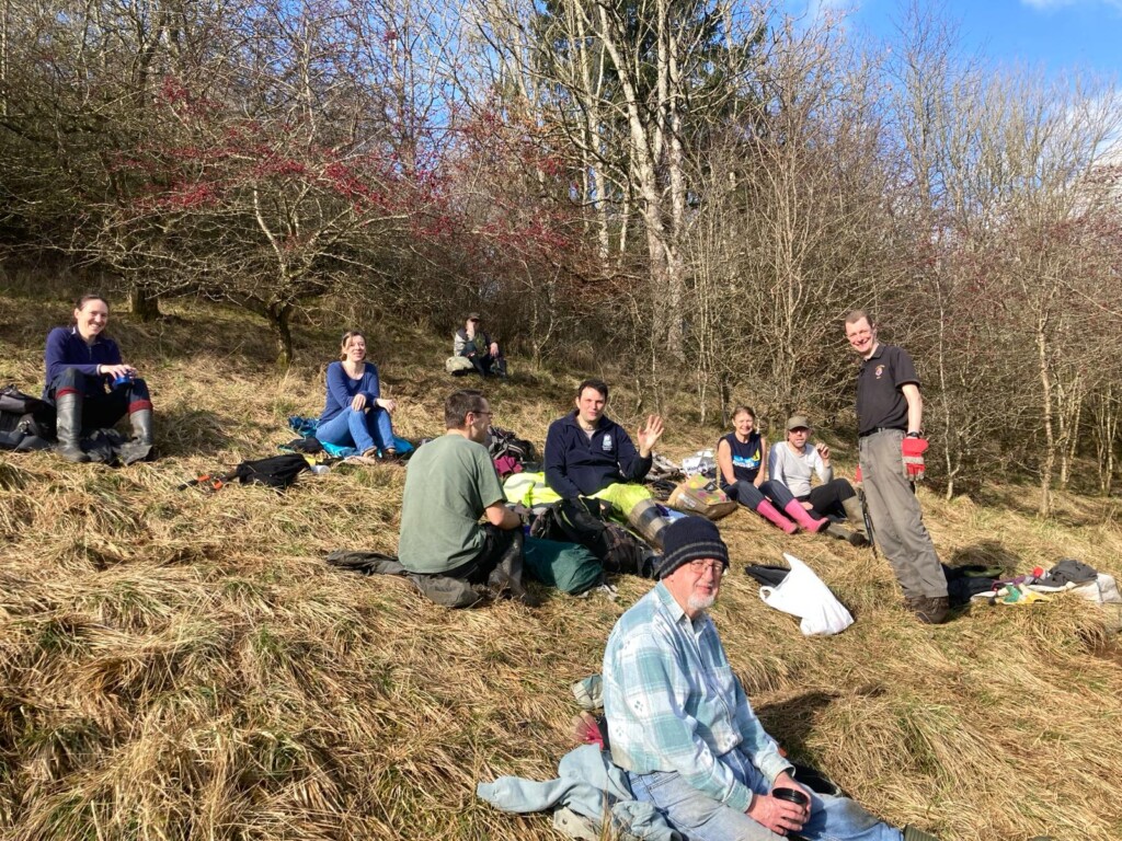 A group of people sitting on a hill

Description automatically generated
